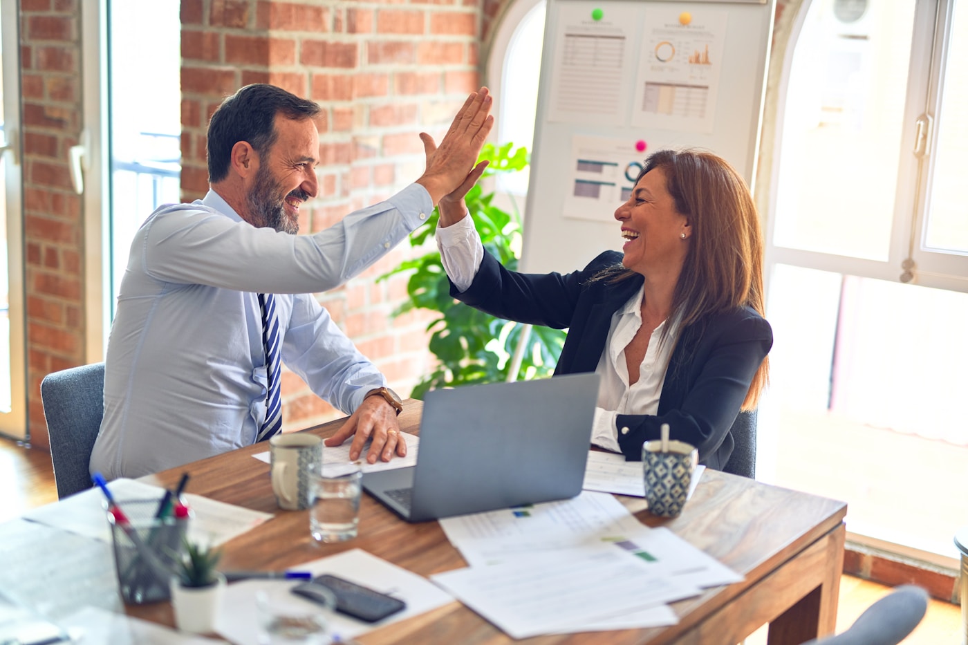 Advisor and learner reviewing AI finance reporting drafts and forecast commentary at a desk