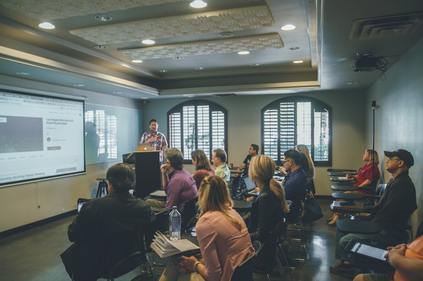 Evening classroom session with professionals reviewing AI finance action plans